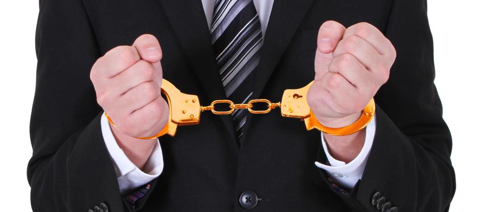 Man in a suit with Golden Handcuffs